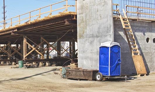 row of portable toilets on a busy job site